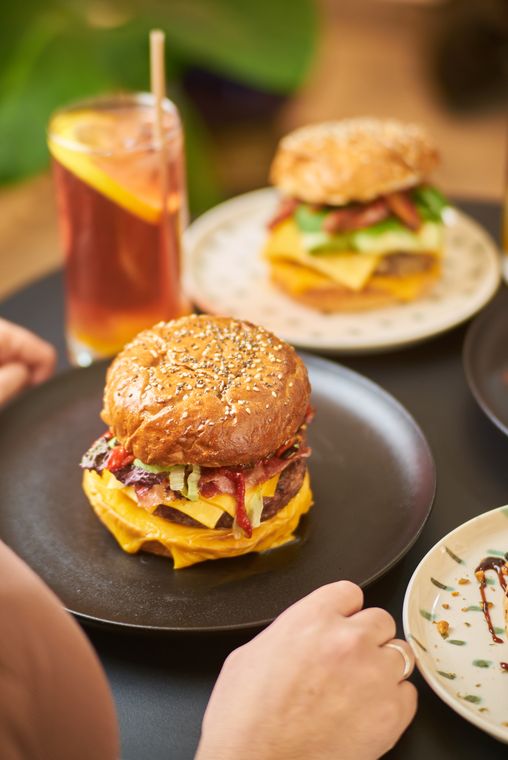 Hamburguesas y té helado en una mesa compartida