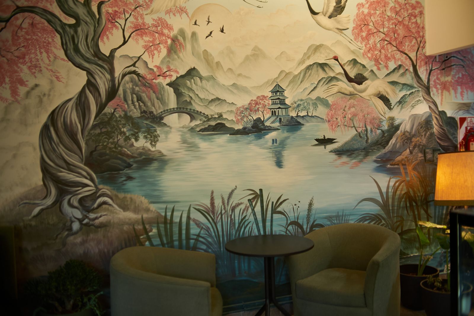 El salón de Manolette’s: sillones, mesas y el gran mural pintado en la pared