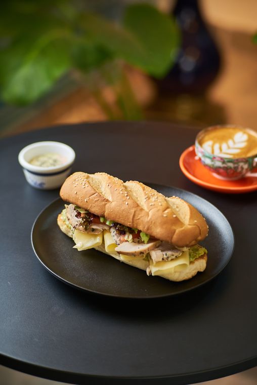 Sándwich de pollo ahumado con queso y palta, con un latte