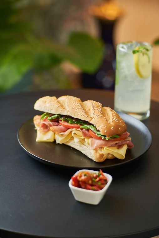 Sándwich italiano de jamón crudo en pan panini, con limonada